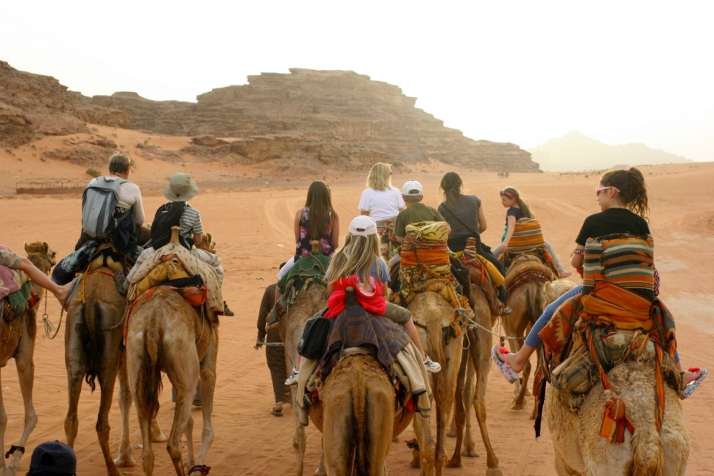 Flea riding a camel on a press trip to Jordan